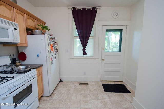 kitchen featuring white appliances, visible vents, and baseboards