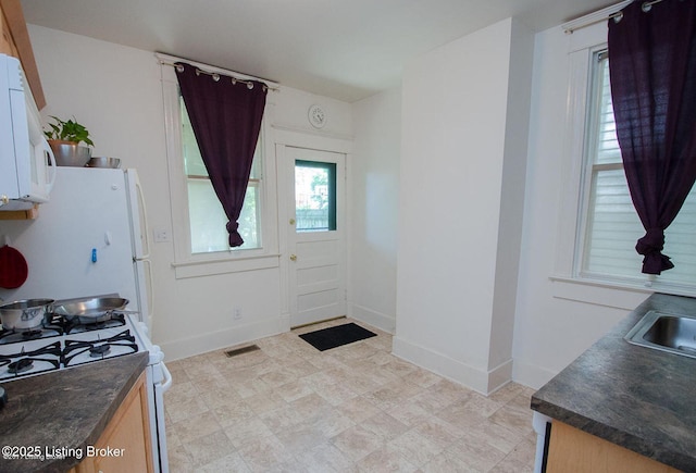 doorway with baseboards and visible vents