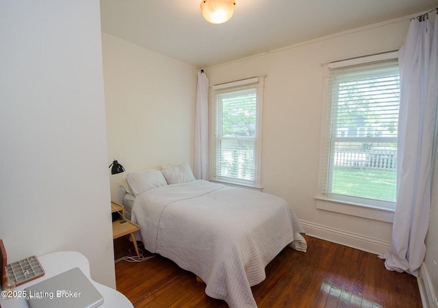 bedroom featuring hardwood / wood-style flooring, multiple windows, and baseboards