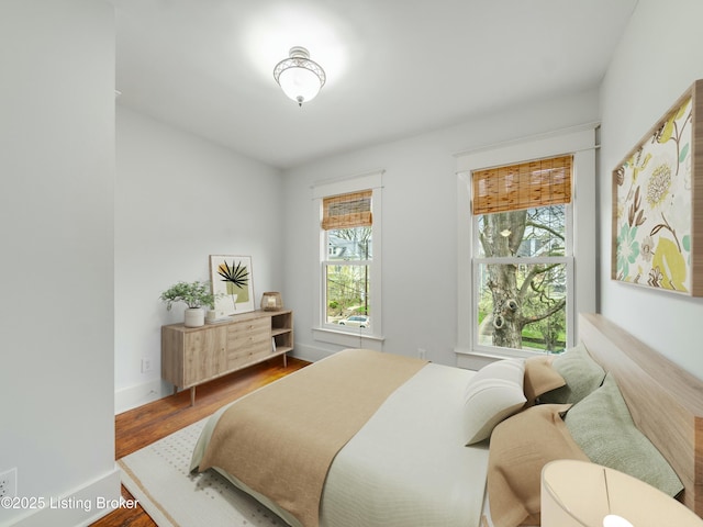 bedroom with baseboards and wood finished floors