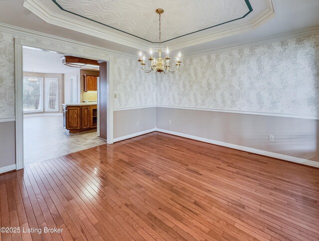 235 Ashford Dr, Mt Washington, KY 40047 - unfurnished room featuring a chandelier, hardwood / wood-style floors, a tray ceiling, ornamental molding, and wallpapered walls