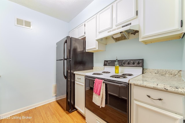 kitchen with electric stove, freestanding refrigerator, light wood-type flooring, under cabinet range hood, and visible vents