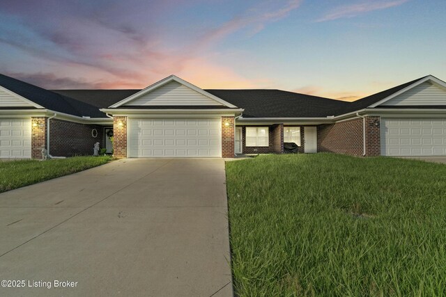 single story home with concrete driveway, a front lawn, brick siding, and a garage