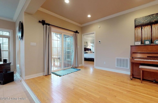 doorway featuring baseboards, a wealth of natural light, visible vents, and light wood-style flooring