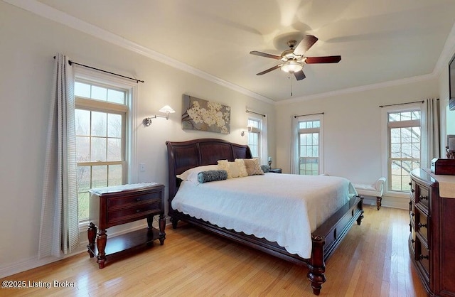 bedroom featuring light wood-type flooring, crown molding, and a ceiling fan
