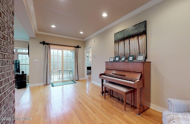 living area featuring light wood-type flooring, baseboards, recessed lighting, and crown molding