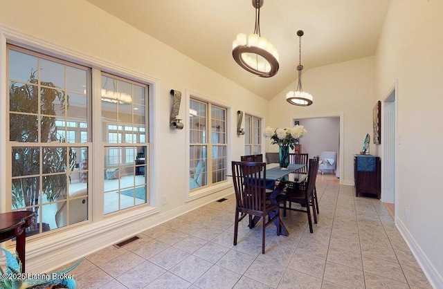 dining room featuring baseboards, visible vents, a chandelier, lofted ceiling, and light tile patterned floors