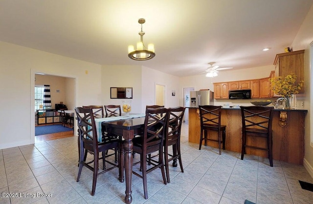 dining area with ceiling fan with notable chandelier, baseboards, visible vents, and light tile patterned floors