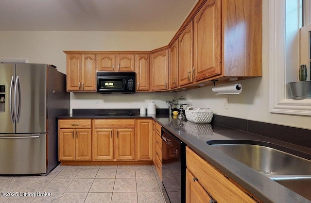 kitchen featuring light tile patterned floors, dark countertops, brown cabinets, and black appliances