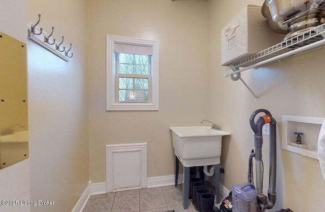 laundry room with baseboards, laundry area, light tile patterned floors, and hookup for a washing machine