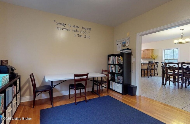 office featuring a chandelier, light wood finished floors, and baseboards