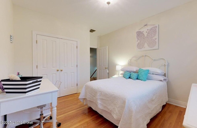 bedroom featuring baseboards, a closet, visible vents, and light wood-type flooring