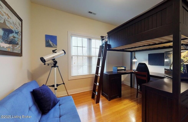 bedroom with baseboards, light wood-style flooring, and visible vents