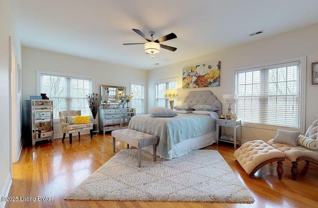 bedroom featuring ceiling fan, wood finished floors, and visible vents