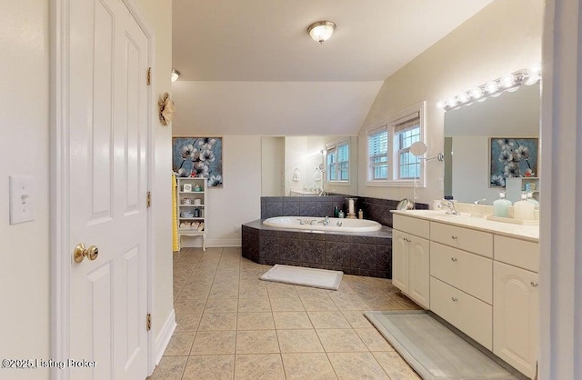 bathroom featuring vaulted ceiling, tile patterned floors, a bath, vanity, and baseboards
