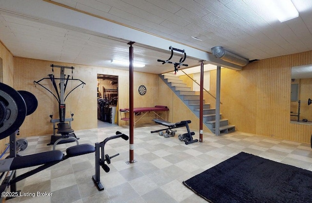workout room with wooden walls and tile patterned floors