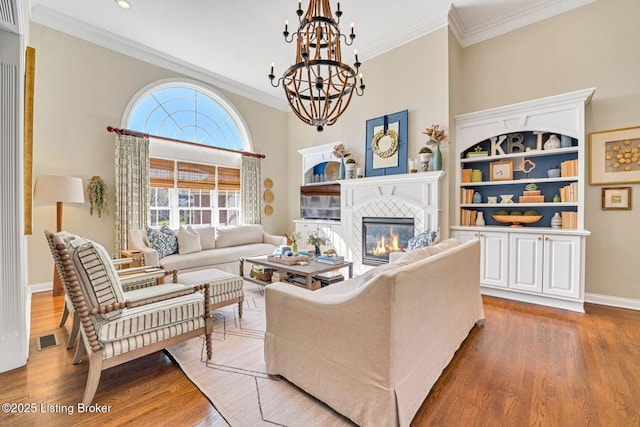 4232 Ashleywood Ct, Louisville, KY 40241 - living room with light wood-type flooring, a notable chandelier, ornamental molding, and a glass covered fireplace