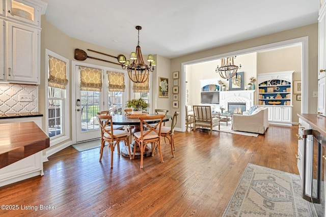 4232 Ashleywood Ct, Louisville, KY 40241 - dining area with a glass covered fireplace, baseboards, an inviting chandelier, and wood finished floors