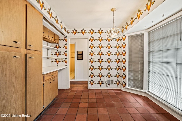interior space with dark tile patterned flooring and a notable chandelier
