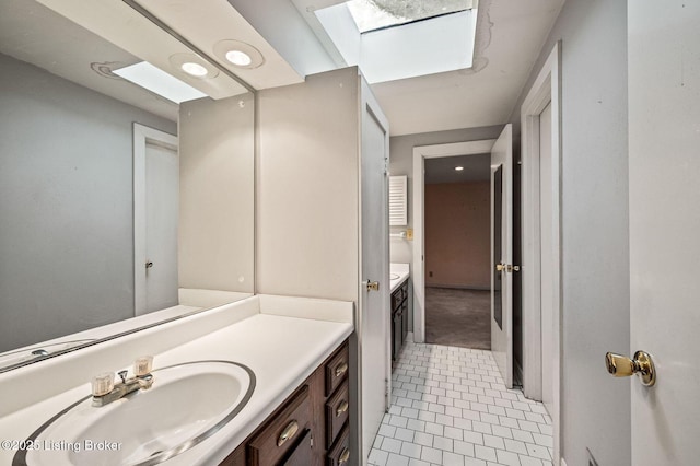 bathroom with tile patterned floors, a skylight, and vanity