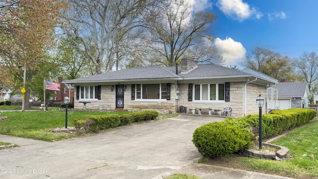 901 S 47th St, Louisville, KY 40211 - view of front of home with stone siding, a front lawn, a chimney, roof with shingles, and concrete driveway