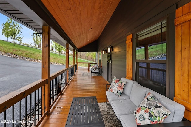 wooden terrace with an outdoor living space and a porch