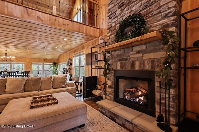 living area featuring an inviting chandelier, recessed lighting, a fireplace, wooden ceiling, and wood finished floors