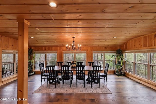 dining space with a chandelier, wood walls, wood ceiling, and vaulted ceiling