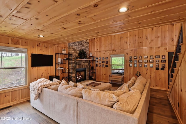 living area with wooden walls, a wealth of natural light, and wood ceiling