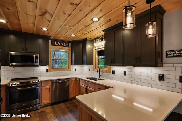 kitchen with a sink, light countertops, dark wood-type flooring, stainless steel appliances, and wooden ceiling
