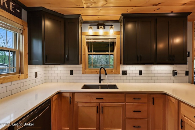 kitchen featuring decorative backsplash, dishwasher, a sink, and light countertops