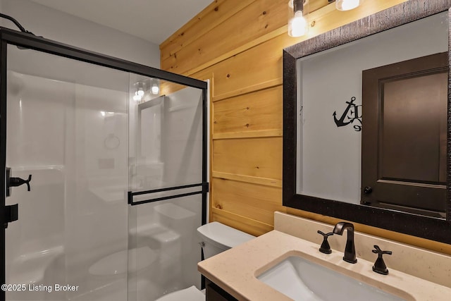 full bathroom with a shower stall, vanity, and toilet