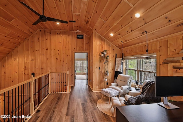 interior space featuring ceiling fan, wood ceiling, wood finished floors, wood walls, and lofted ceiling