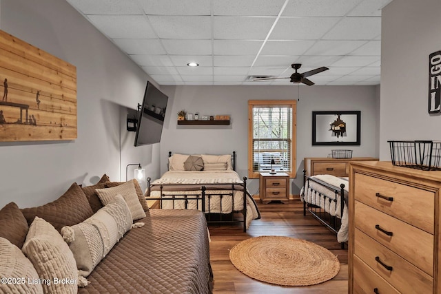 bedroom featuring a ceiling fan, a paneled ceiling, and dark wood-style floors