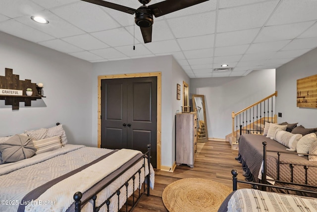 bedroom with a paneled ceiling, wood finished floors, and recessed lighting