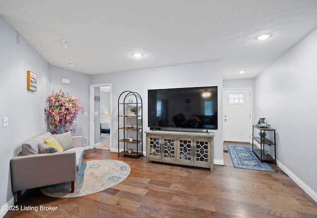 living area with recessed lighting, baseboards, and wood finished floors
