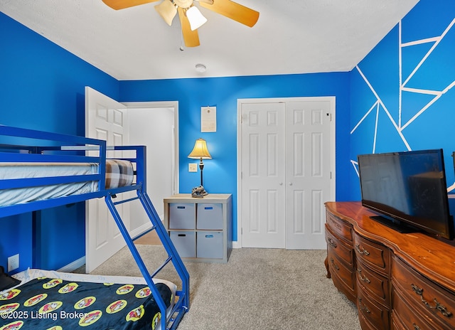 carpeted bedroom featuring a closet and a ceiling fan