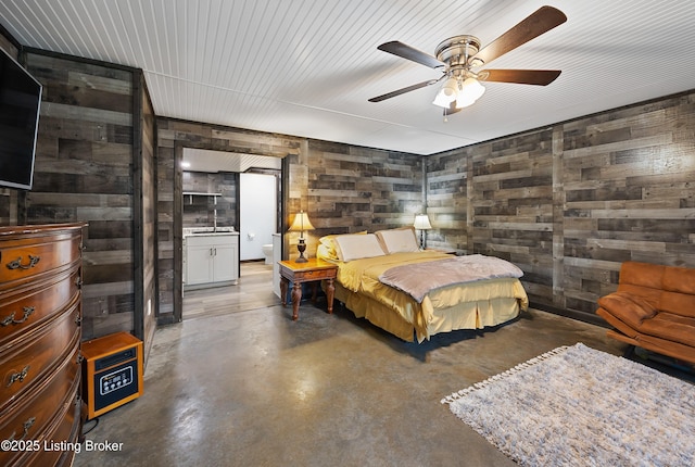 bedroom with finished concrete floors, wooden walls, and a ceiling fan