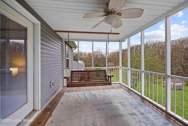unfurnished sunroom featuring ceiling fan