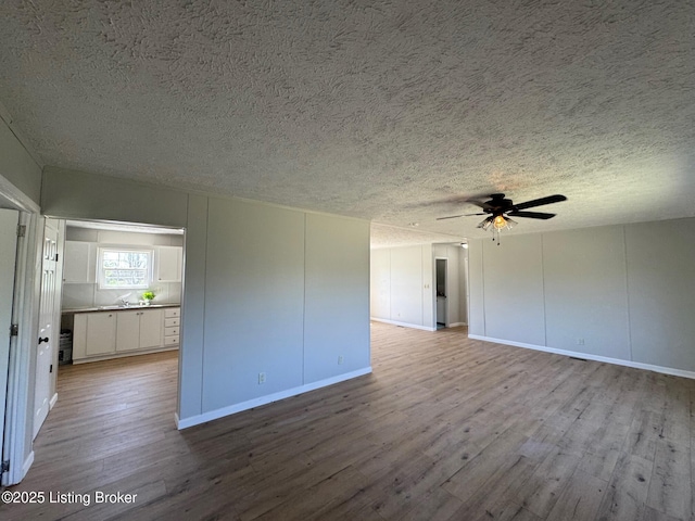 490 Blackjack Rd, Radcliff, KY 40160 - unfurnished living room featuring a textured ceiling, wood finished floors, ceiling fan, and baseboards