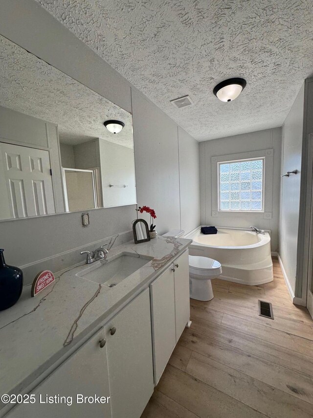 490 Blackjack Rd, Radcliff, KY 40160 - bathroom with hardwood / wood-style floors, a textured ceiling, vanity, a shower stall, and a bath