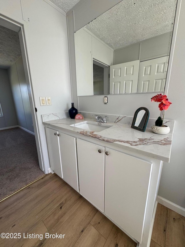 490 Blackjack Rd, Radcliff, KY 40160 - kitchen featuring a sink, a textured ceiling, light wood finished floors, white cabinetry, and baseboards