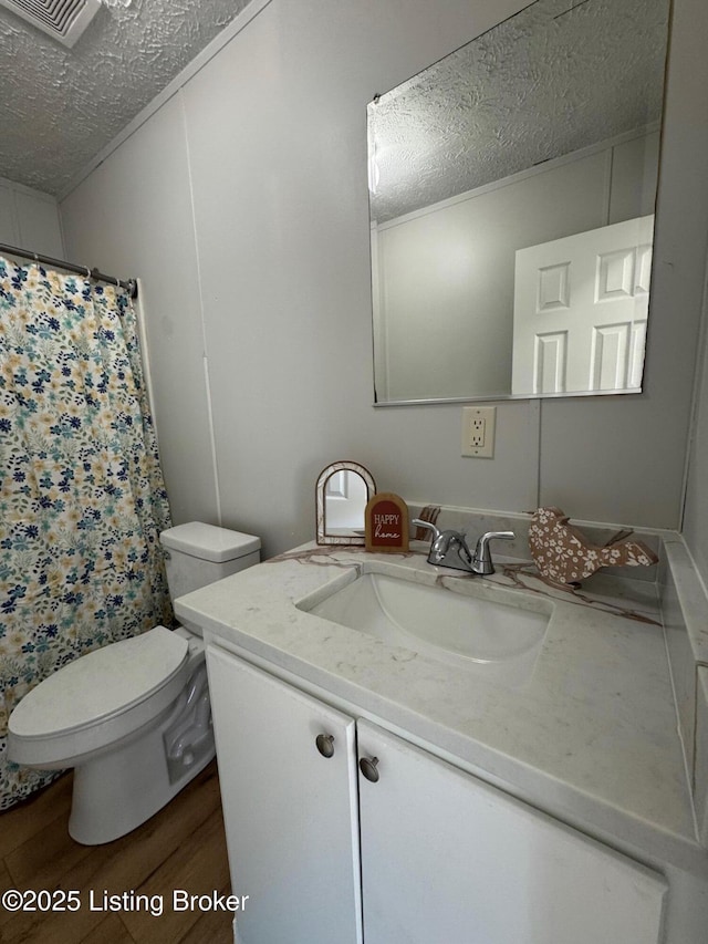 490 Blackjack Rd, Radcliff, KY 40160 - full bathroom featuring a textured ceiling, wood finished floors, toilet, vanity, and a shower with curtain