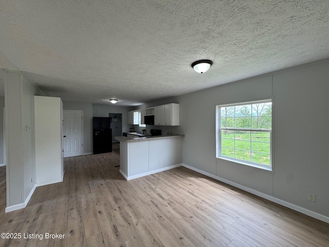 490 Blackjack Rd, Radcliff, KY 40160 - kitchen featuring a peninsula, light wood-type flooring, open floor plan, freestanding refrigerator, and a textured ceiling