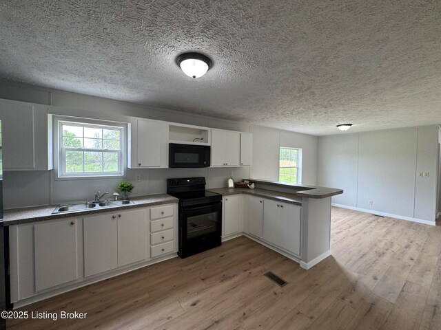 490 Blackjack Rd, Radcliff, KY 40160 - kitchen featuring black appliances, a sink, a peninsula, light wood-style floors, and a textured ceiling