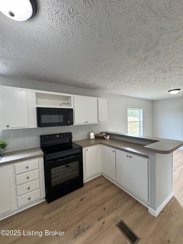490 Blackjack Rd, Radcliff, KY 40160 - kitchen featuring black appliances, light wood finished floors, a textured ceiling, a peninsula, and white cabinets