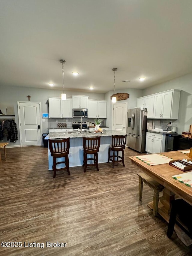 117 Richwood Cir, Georgetown, KY 40324 - kitchen featuring stainless steel appliances, backsplash, a breakfast bar, dark wood-type flooring, and white cabinets