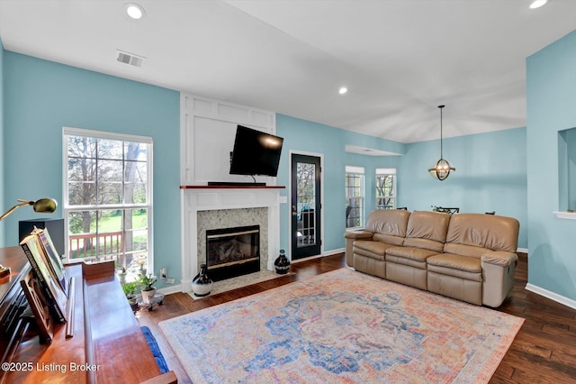 living room featuring visible vents, recessed lighting, plenty of natural light, and a premium fireplace