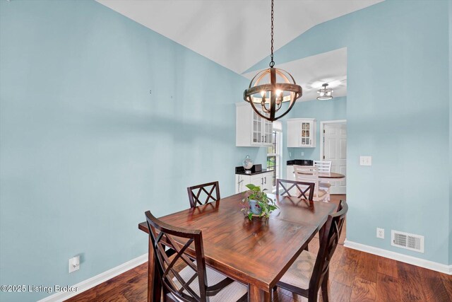 dining room featuring an inviting chandelier, vaulted ceiling, visible vents, dark wood-style flooring, and baseboards