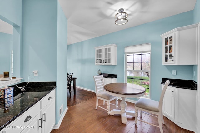 dining area featuring visible vents, baseboards, and dark wood-style floors